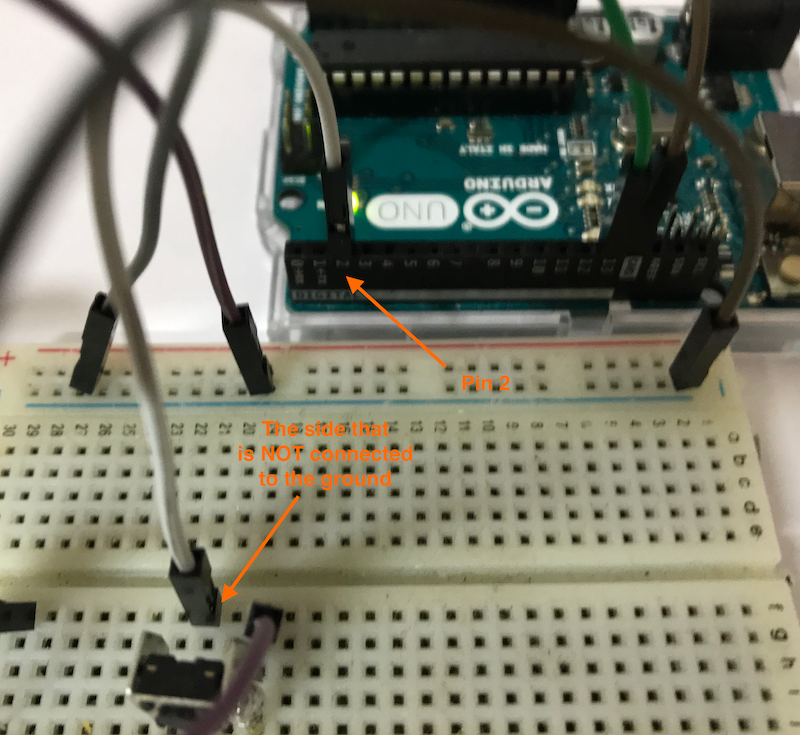 The white wire connects the side of the button NOT connected to the ground and the Pin 2 of the Arduino.